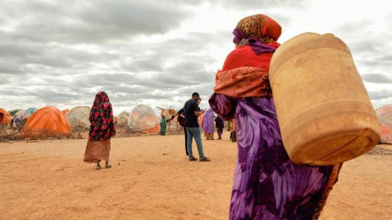 Una adulta mayor carga un bidón en un asentamiento informal que alberga a casi 3 mil personas desplazadas en Doolow, Somalia. La mayoría de las personas que viven aquí han sido desplazadas debido a la sequía.