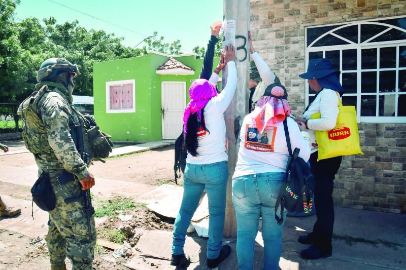 $!Marinos custodian la brigada de madres buscadoras que acudieron hace días a Navolato para pegar las fichas de desaparición de sus hijos.