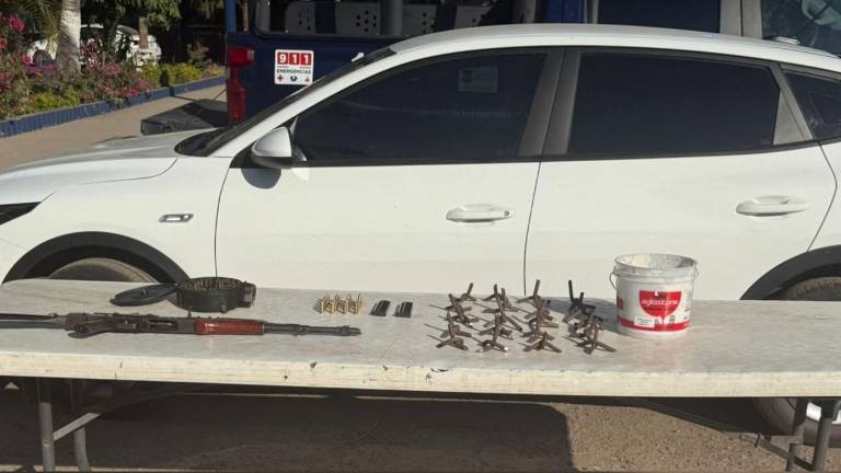 El vehículo Kia blanco, con reporte de robo, fue encontrado abandonado junto al armamento y ponchallantas en Culiacán.