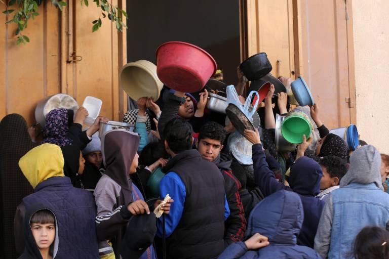 En medio de la desesperación habitantes de Gaza buscan comida en los camiones