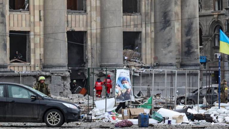Trabajadores municipales evalúan los daños ocasionados por los bombardeos rusos sobre el centro de la ciudad ucraniana de Járkov.