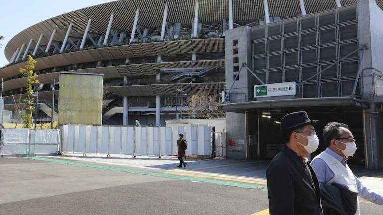 Gente camina frente al Estadio Nacional de Tokio, el miércoles 10 de marzo de 2021.