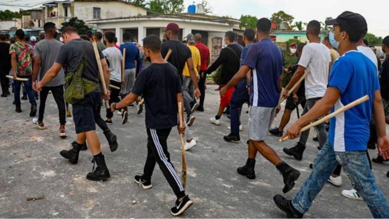 Jóvenes que apoyan al régimen castrista, con palos, se unieron a las fuerzas de seguridad en el municipio de Arroyo Naranjo, La Habana.
