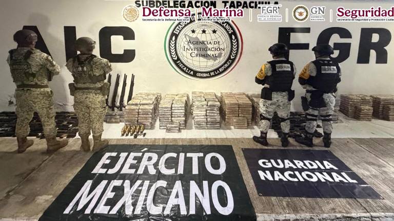 Autoridades resguardan las armas y droga aseguradas tras catear un inmueble en Chiapas.