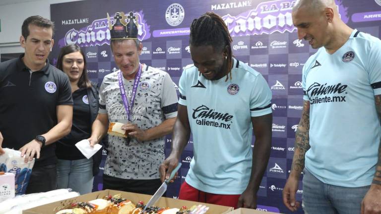 Aké Loba y Ariel Nahuelpán parten la rosca de Reyes durante su presentación.