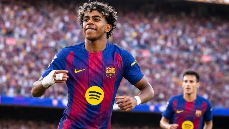 Alt: Futbolista corre por el campo durante un partido.