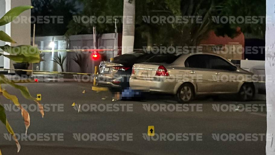 El cuerpo del hombre asesinado a balazos quedó entre dos vehículos estacionados frente a la plaza comercial.