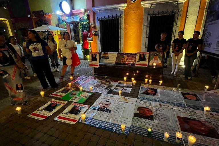 Lonas, fotos y velas fueron puestas sobre el suelo y bancas frente al teatro Ángela Peralta.