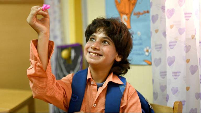 Mahmoud, un niño con autismo, participa en una actividad con letras en Egipto.