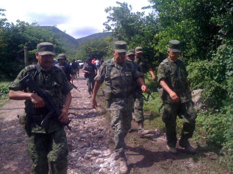 $!Oficiales y soldados del ejército caminan cerca del basurero de Cocula en noviembre de 2014.