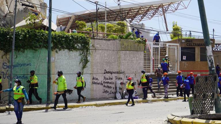 Familiares han escrito los nombres de sus seres queridos desaparecidos en una pared del lugar donde trabajan los servicios de emergencia.