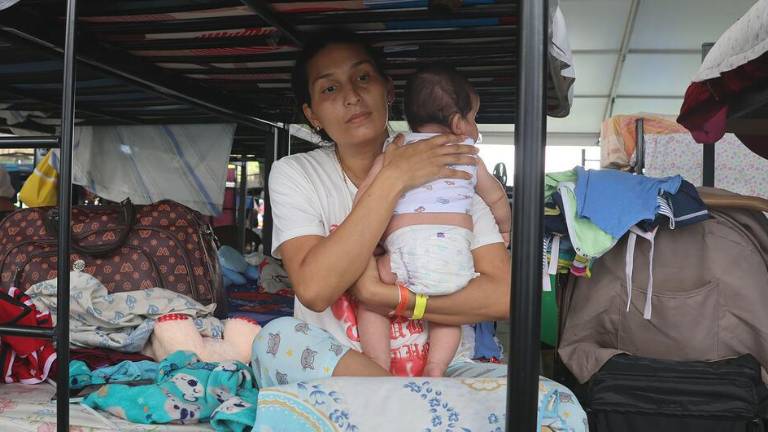 Una mujer desplazada cuida a su hijo de dos meses en un campamento provisional en La Guaira, Venezuela.