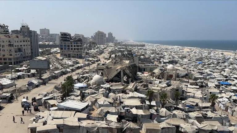 Un enorme asentamiento de tiendas de campaña con residentes desplazados se extiende a lo largo de la costa dañada de Gaza.