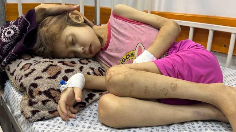 Una madre se sienta junto a la cama de su hija de nueve años en un hospital de la ciudad de Gaza el 25 de agosto de 2025.