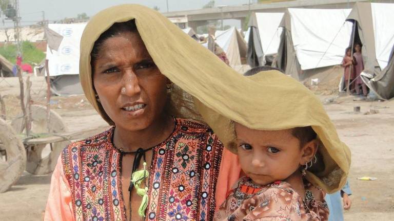 Una mujer cubre a su hija para protegerla del calor extremo en Sindh, Pakistán.