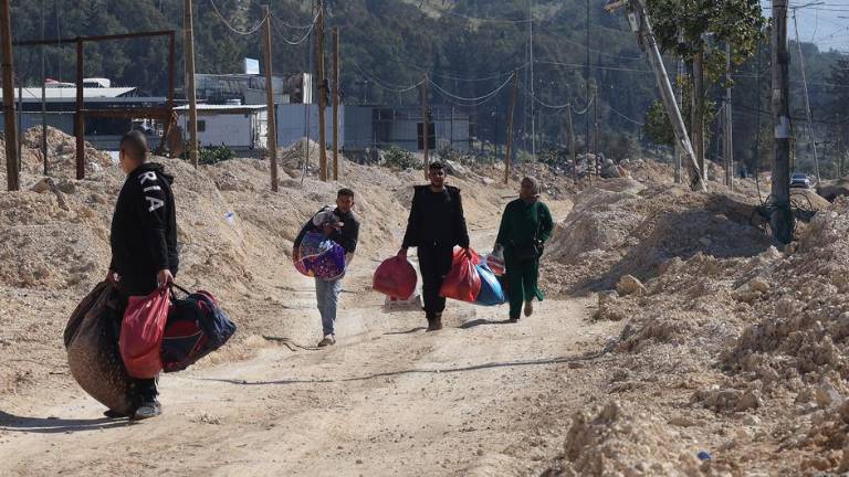 Los miembros de una familia palestina llevan sus pertenencias en el campo de refugiados de Nur Shams, en el norte de Cisjordania.