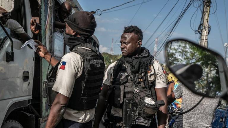 La policía haitiana comprueba los documentos de un conductor en un puesto de control.