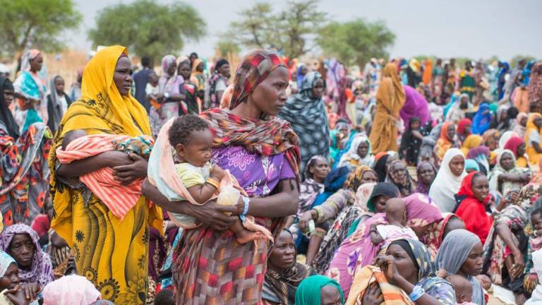 Cientos de refugiados sudaneses recién llegados se reúnen para recibir kits de ayuda del ACNUR en el centro de Madjigilta, en la región chadiana de Ouaddaï.