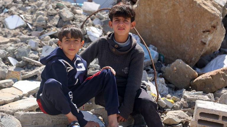 Niños palestinos sentados entre los escombros de las casas destruidas en el campo de Yabalia, al norte de Gaza.