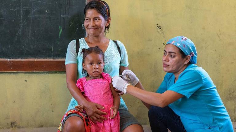 Una niña de dos años recibe la vacuna contra la gripe en un dispensario móvil de Loreto, Perú.
