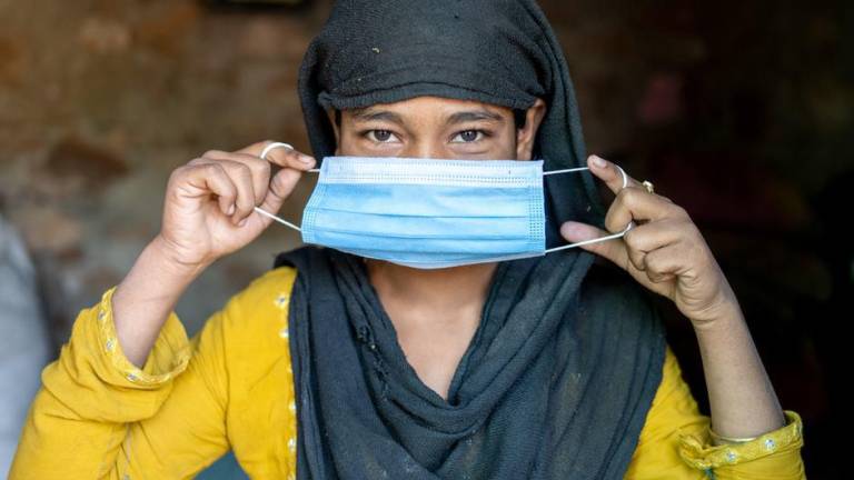 Una mujer en la India se coloca una mascarilla como protección contra el Covid-19.