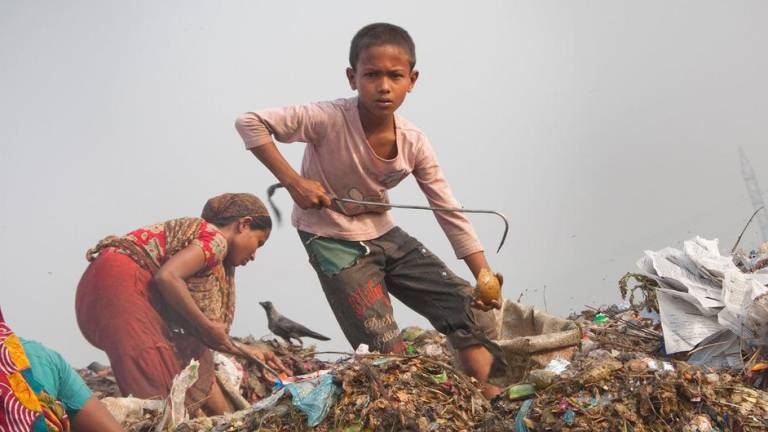 Un niño de diez años trabaja en condiciones peligrosas e insalubres en un vertedero de Dhaka, Bangladesh.