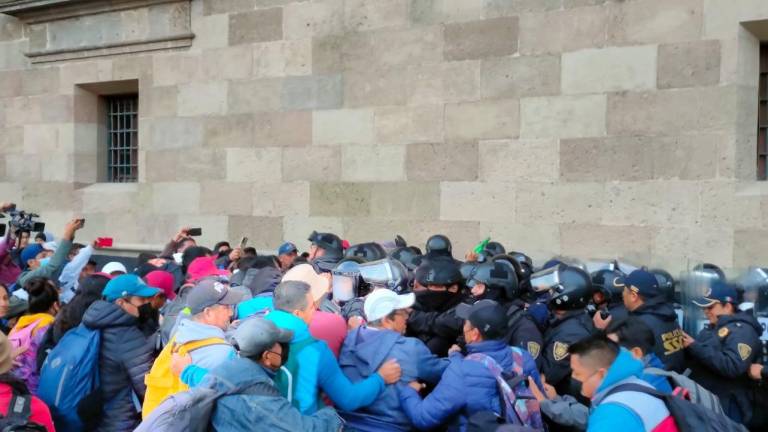 Miembros de la CNTE se enfrentaron a policías antimotines en su intento por ingresar a Palacio Nacional.
