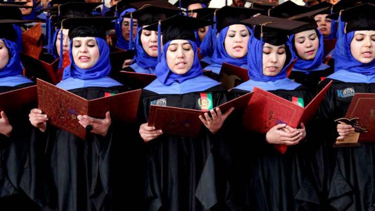 Estudiantes afganos realizan sus promesas de graduación durante la ceremonia de entrega de diplomas en una universidad de Herat, Afganistán.