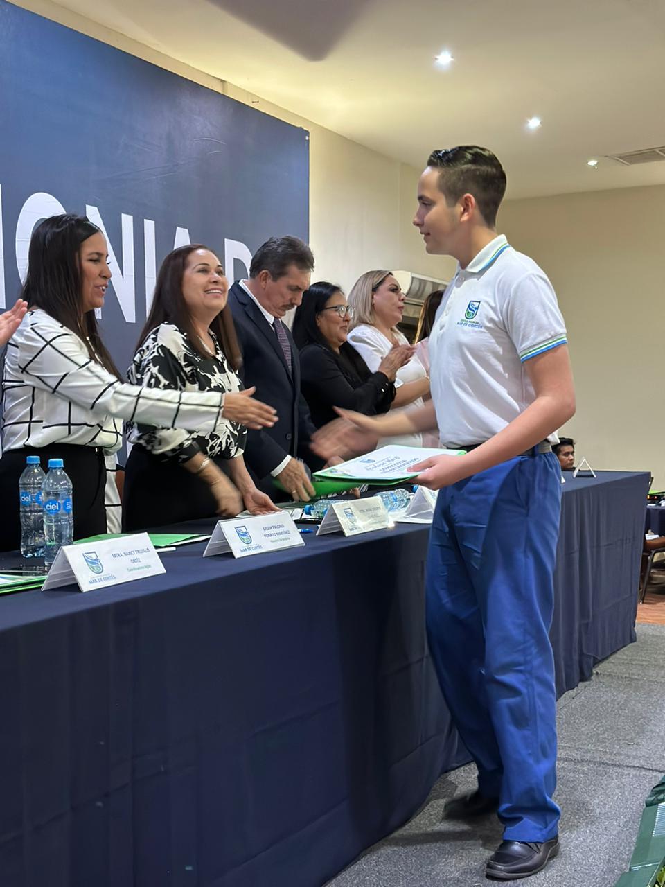 $!César Alejandro López Cota recibe la felicitación de su maestra Paloma Peinado.