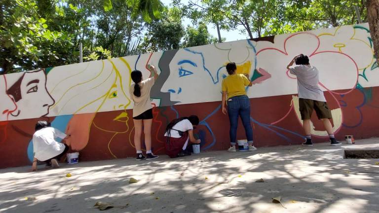 Estudiantes de secundaria en Culiacán trabajan en la creación de un mural en su plantel educativo.