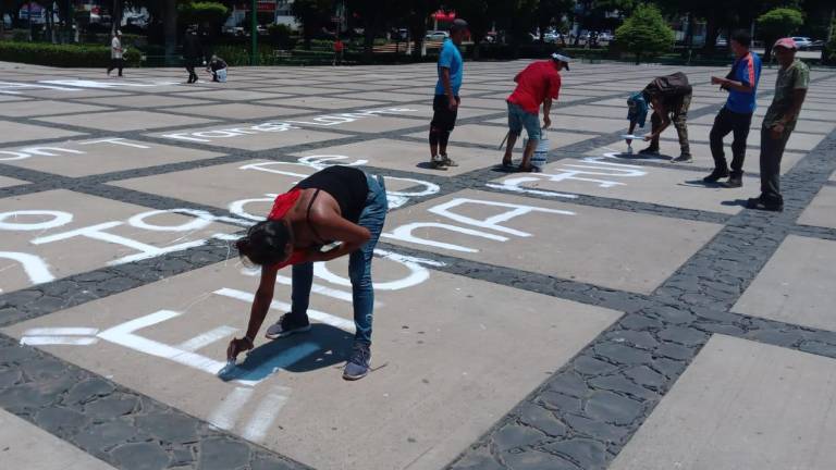 En la plaza cívica del Palacio de Gobierno estatal, familiares de las víctimas del ataque de presuntos marinos en Villa Juárez pintaron mensajes de justicia.