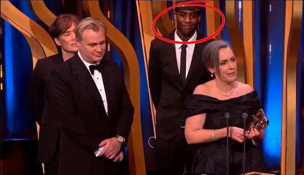$!Mientras Emma Thomas daba el discurso al recibir el galardón como Mejor Película, la cámara captó sobre el escenario a un hombre que no era parte del equipo de Oppenheimer.