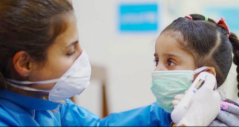 Una enfermera toma la temperatura a una niña en un Centro de Atención Primaria de Salud en Beirut, Líbano, durante el brote de Covid-19.