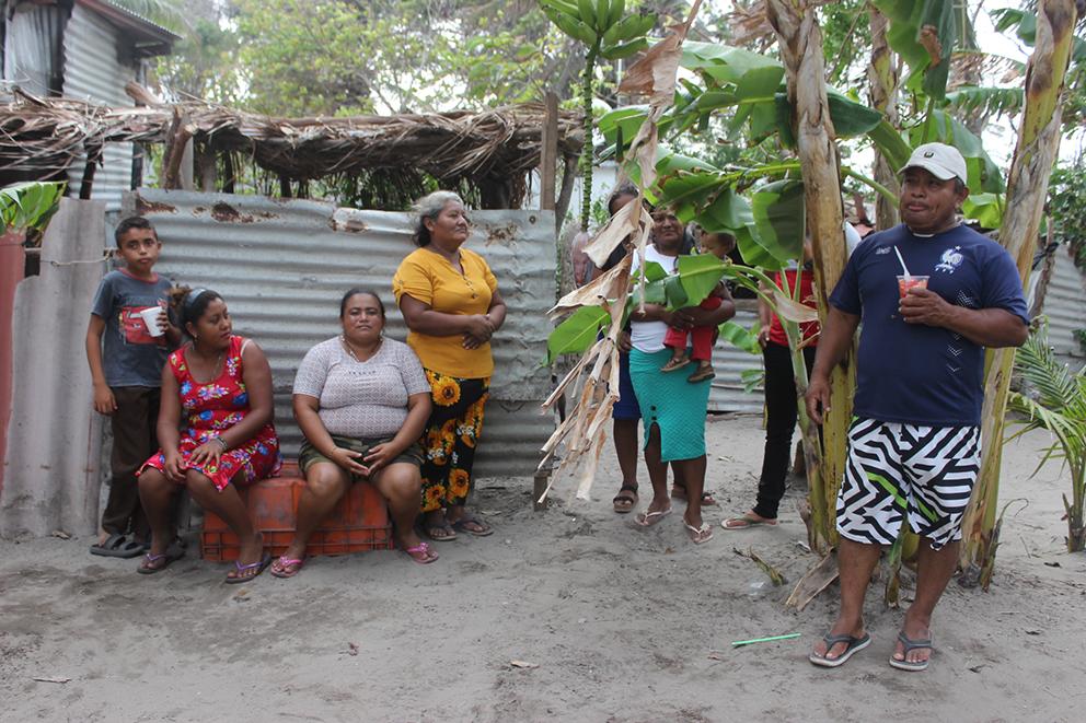 $!Una familia descansa afuera de un refugio temporal en el que viven desde que las olas sepultaron sus casas.