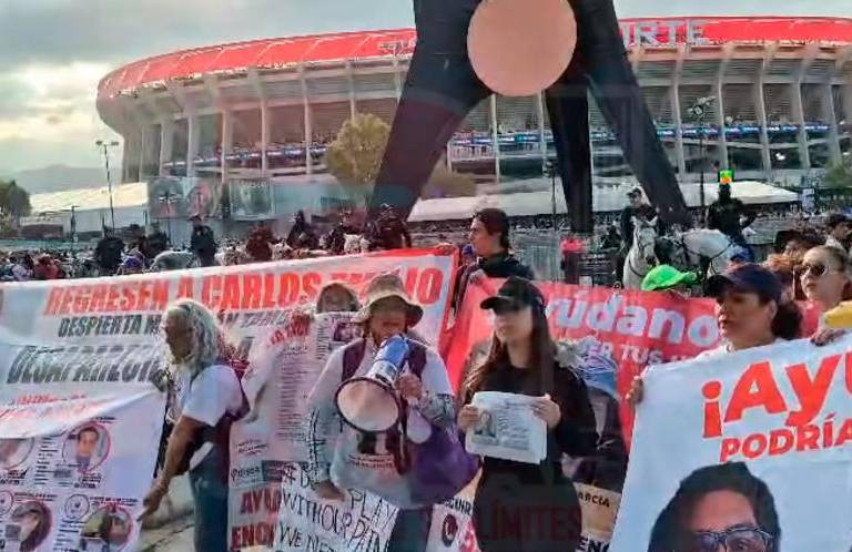 Buscadoras pegan fotos en el Estadio Azteca